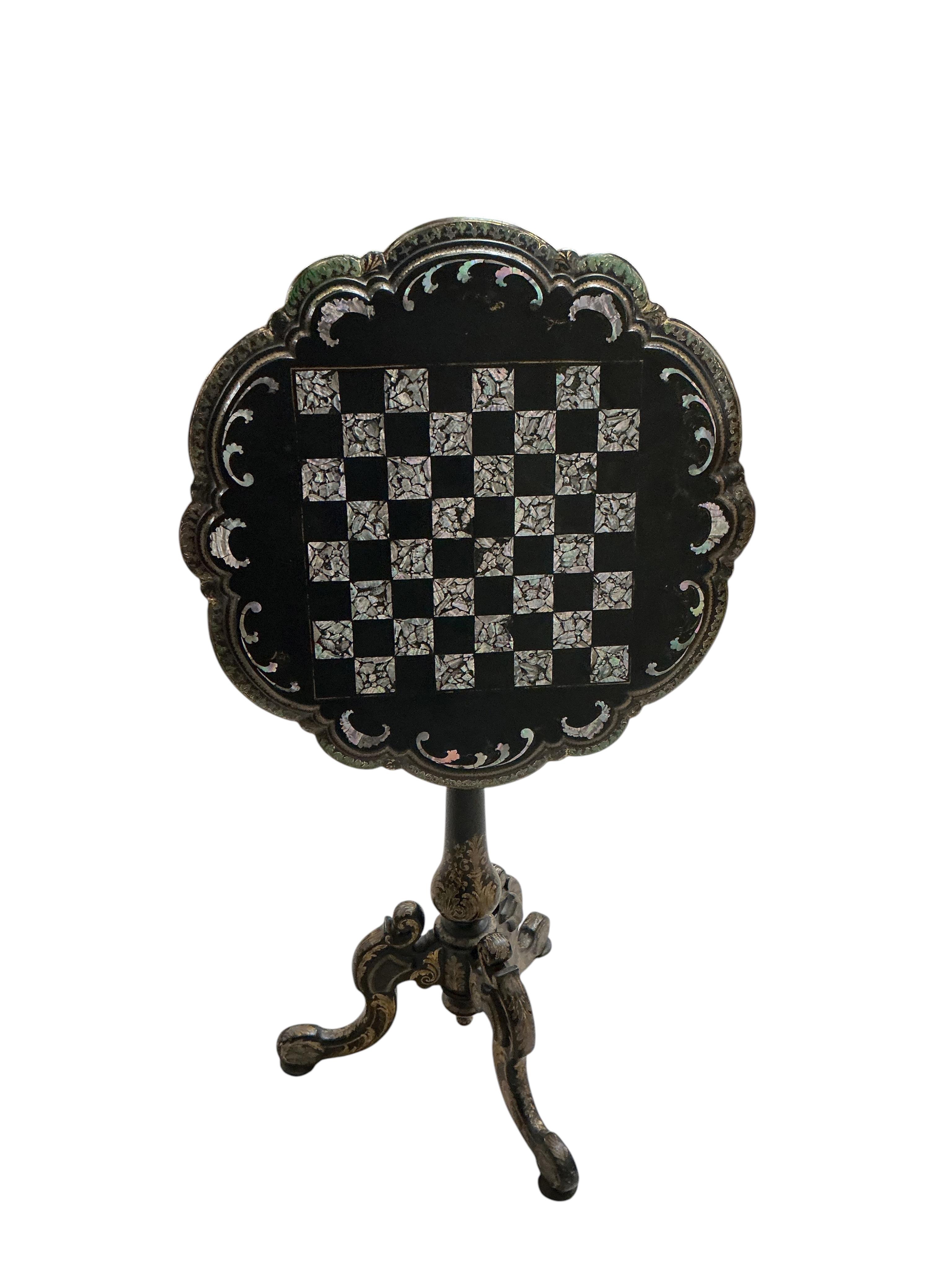 A Victorian mother of pearl inlaid papier mache circular tilt top tripod games table, diameter 56cm, height 74cm